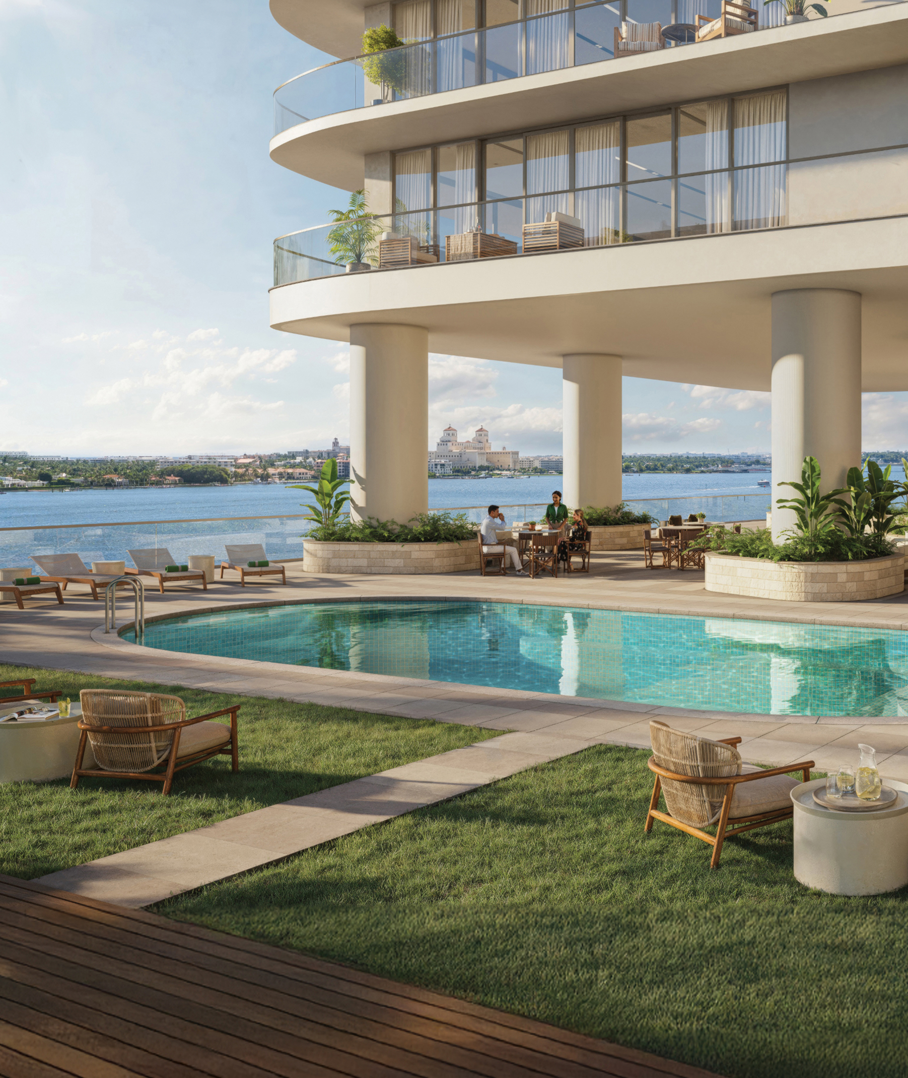 Luxury waterfront residential pool deck with lounge seating, landscaped planters, and curved modern balconies overlooking the water.